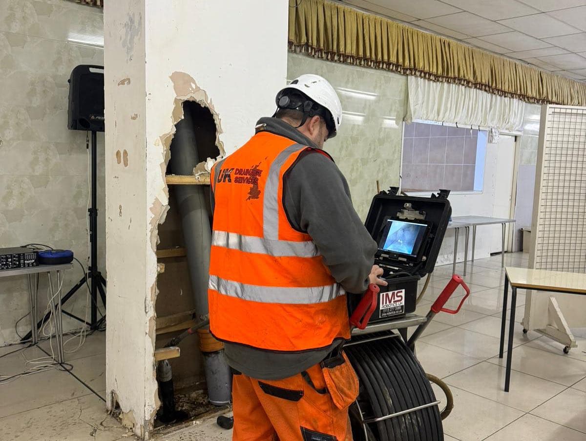 Engineer viewing CCTV footage in UK Drainage Services high-vis