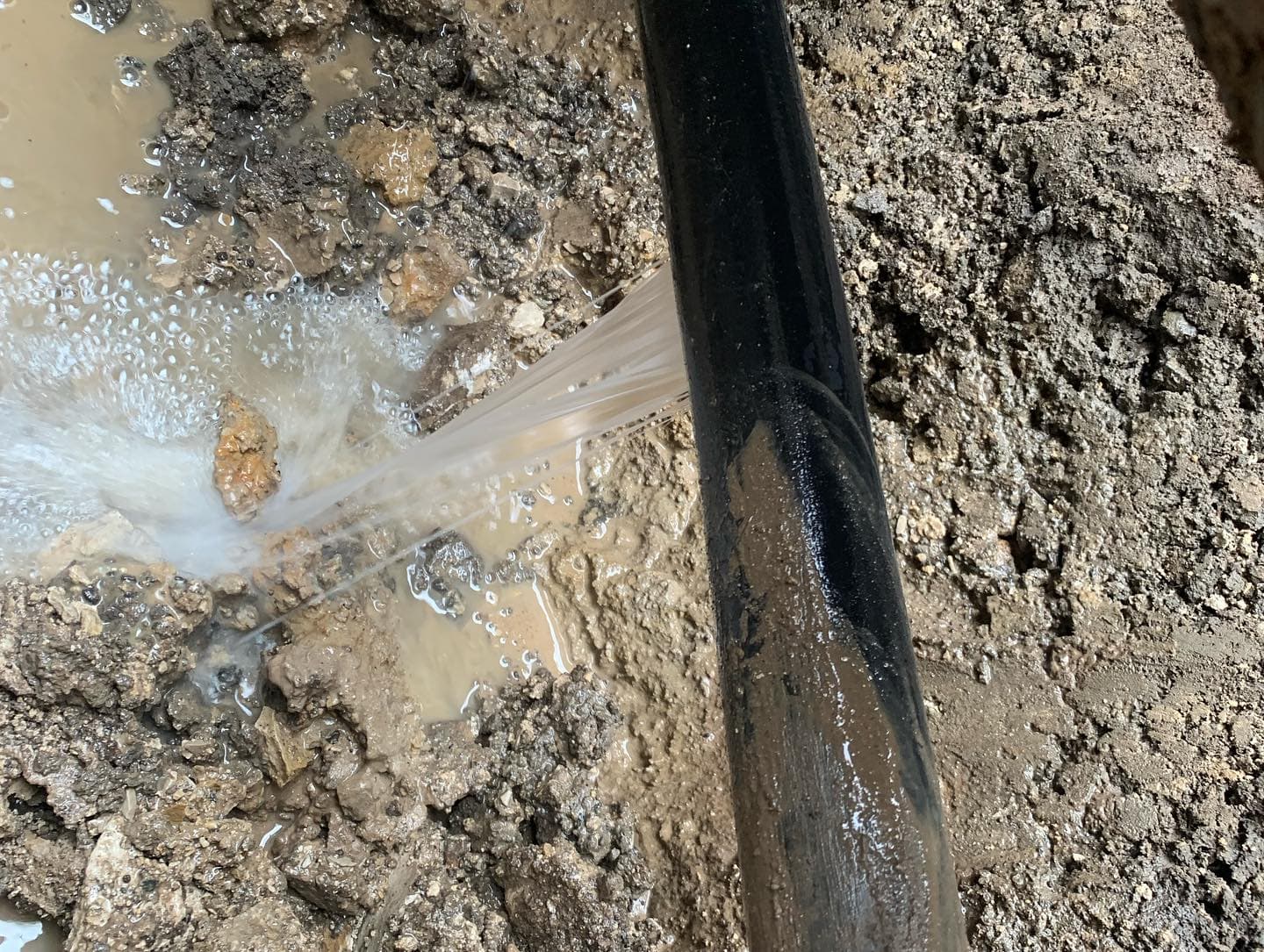 Water gushing from broken pipe at leak location