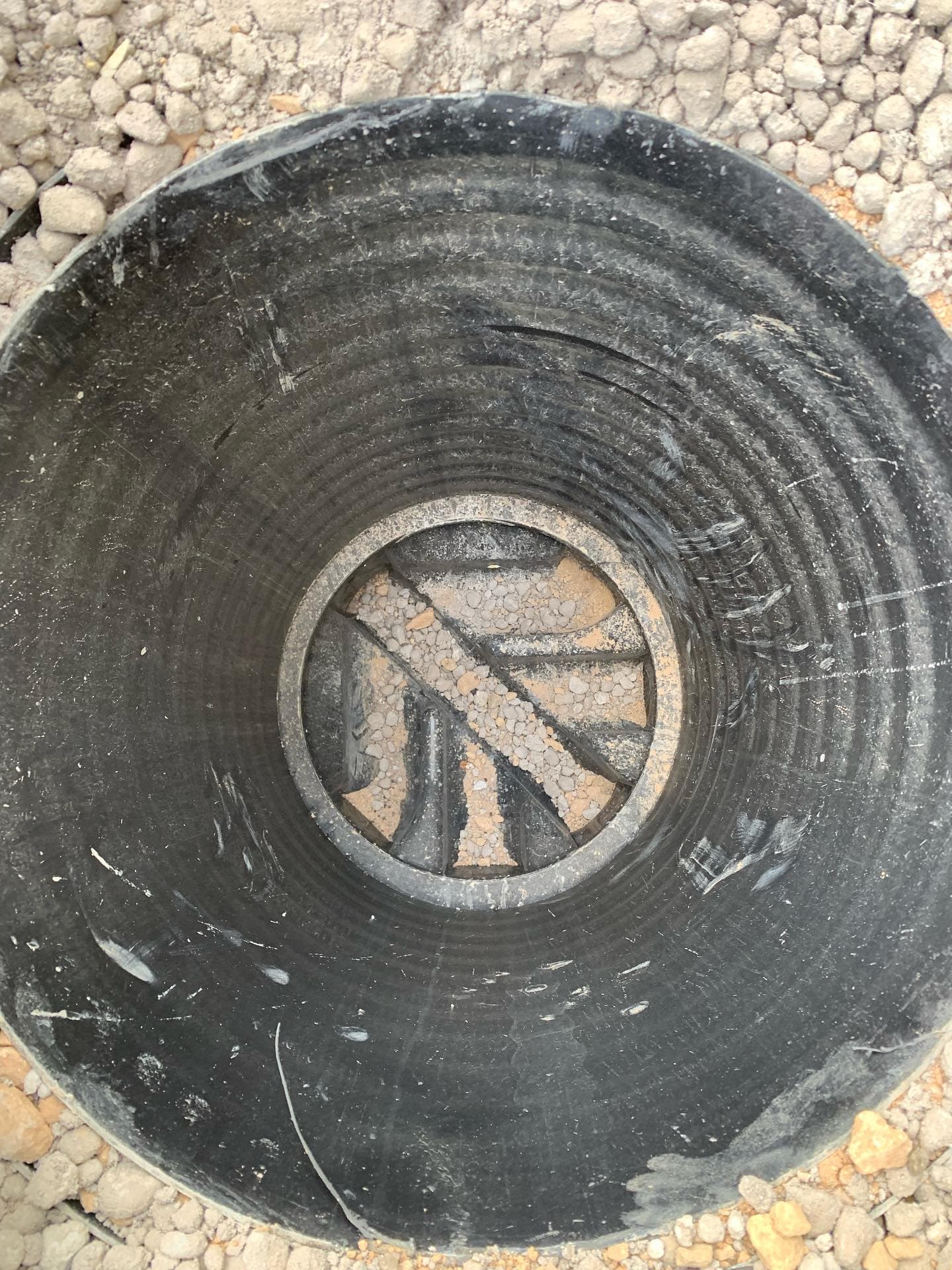 Blocked drain filled with gravel before cleaning